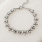 Pulsera de eslabones circulares con dijes de gota en plateado