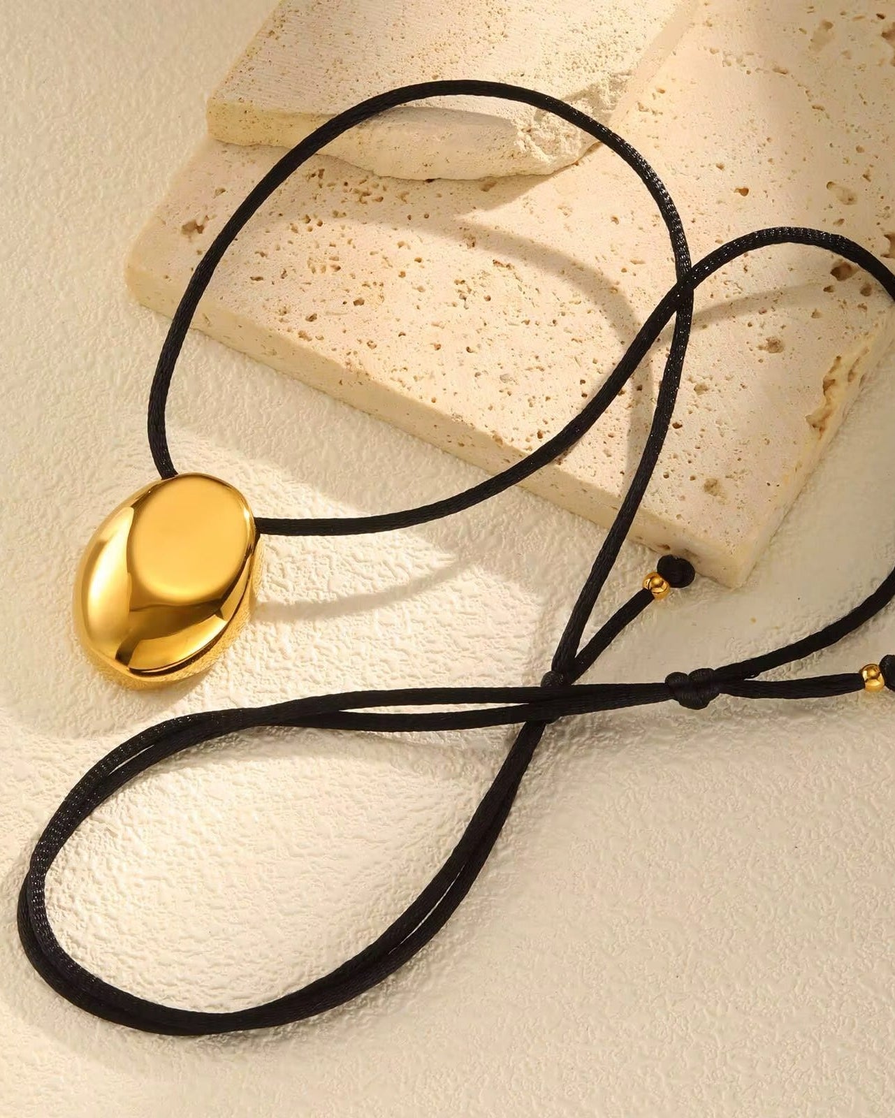 Collar con cordon negro y ovalo dorado