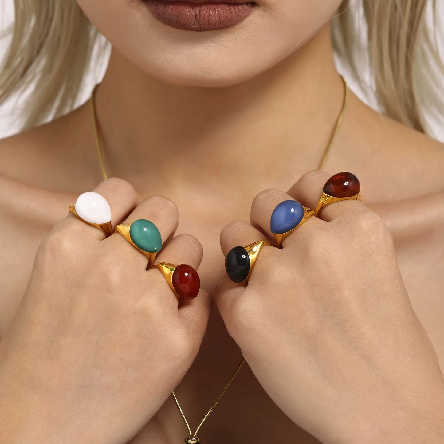 Anillo dorado con piedra de gota color negro, de tipo ajustable.