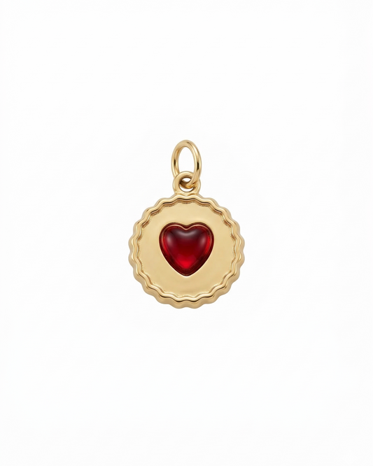 Dije de medalla dorada con corazón de cristal color rubí