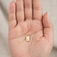Dije de placa rectangular dorada con inicial grabada
