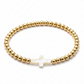 Pulsera dorada con diseño de cruz en perla