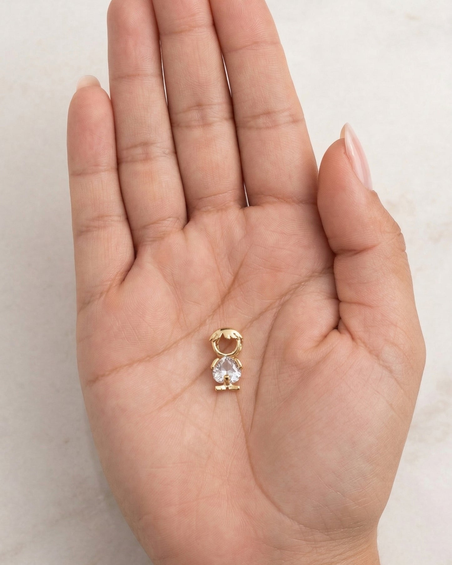 Dije de silueta de niño dorado con cuerpo de cristal
