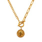 Collar que combina dos estilos de cadenas de eslabones, con un broche redondo, del cual cuelga un dije dorado con forma de moneda.