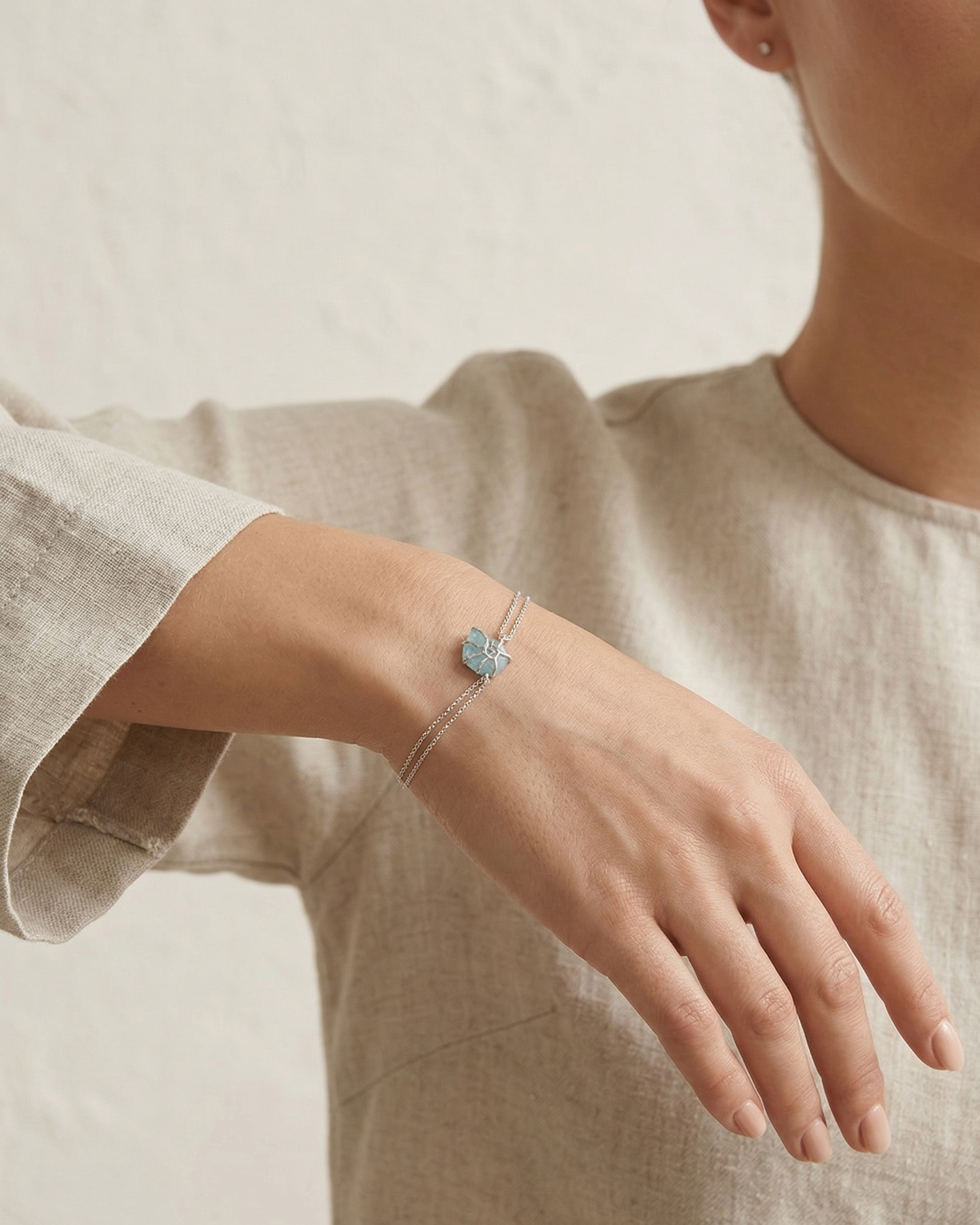 Pulsera de doble cadena con detalle de caracol y deposito de color azul mar y plata