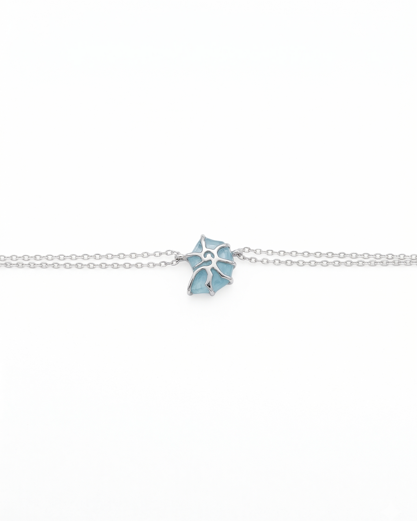 Pulsera de doble cadena con detalle de caracol y deposito de color azul mar y plata