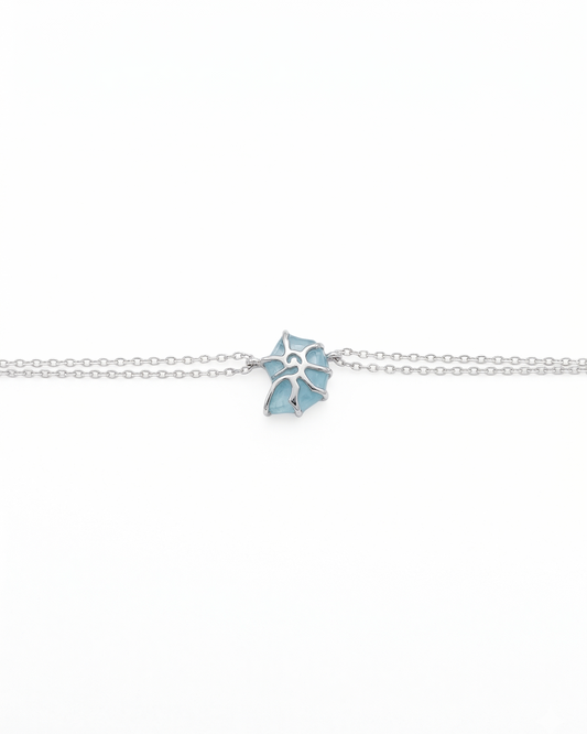 Pulsera de doble cadena con detalle de caracol y deposito de color azul mar y plata