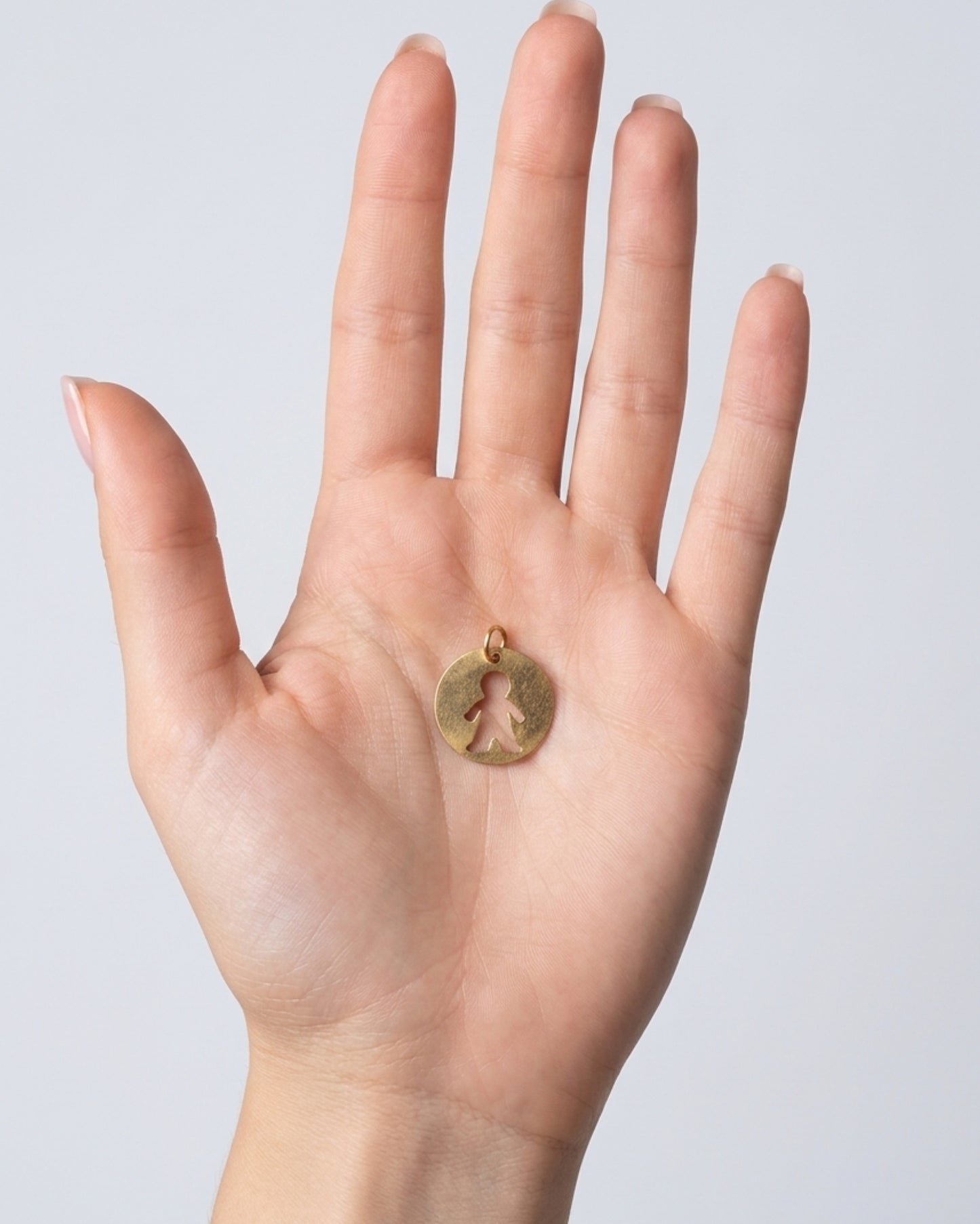 Dije medallón circular con silueta calada de niño