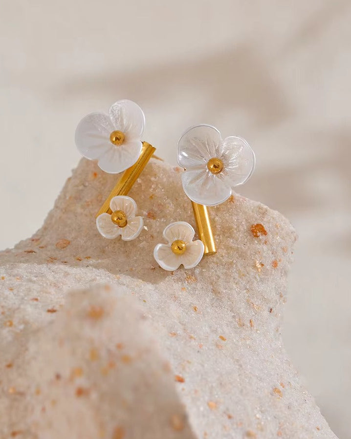 Aretes con diseño de flores blancas tipo studs dorado