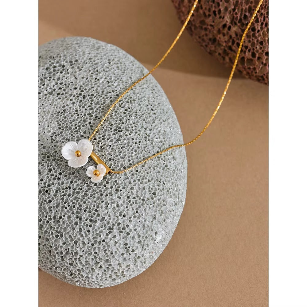 Collar dorado con diseño de flores blancas