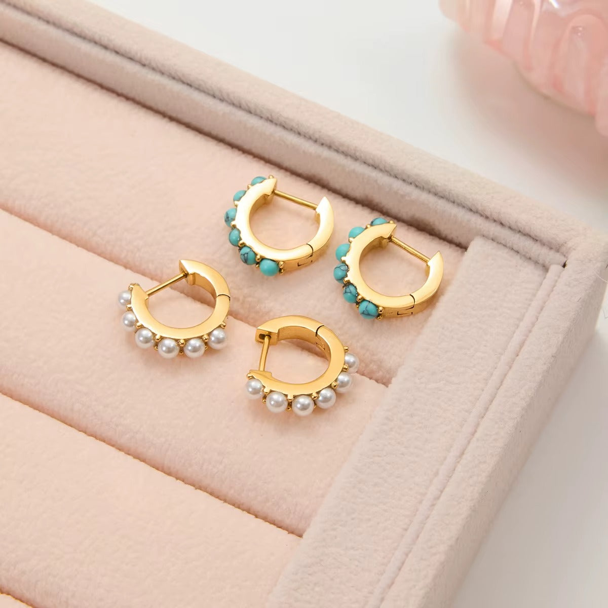 Arete dorado con piedras color turquesa, de tipo huggie.