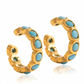 Arete dorado con piedras color turquesa, de tipo ear cuff.