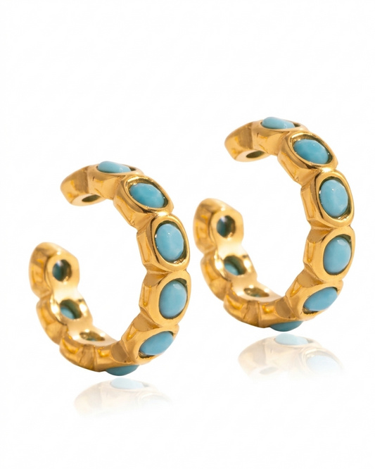 Arete dorado con piedras color turquesa, de tipo ear cuff.