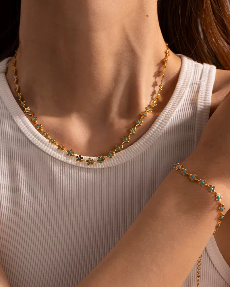 Pulsera de flores en color dorado y turquesa.