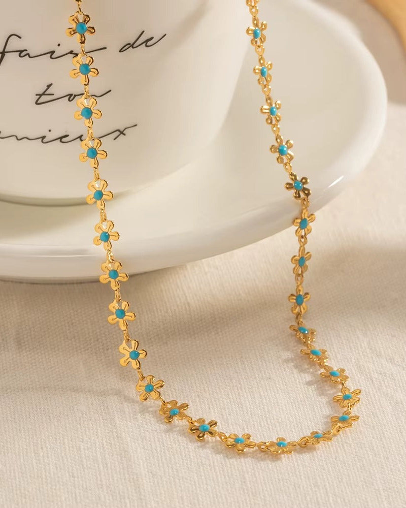 Pulsera de flores en color dorado y turquesa.