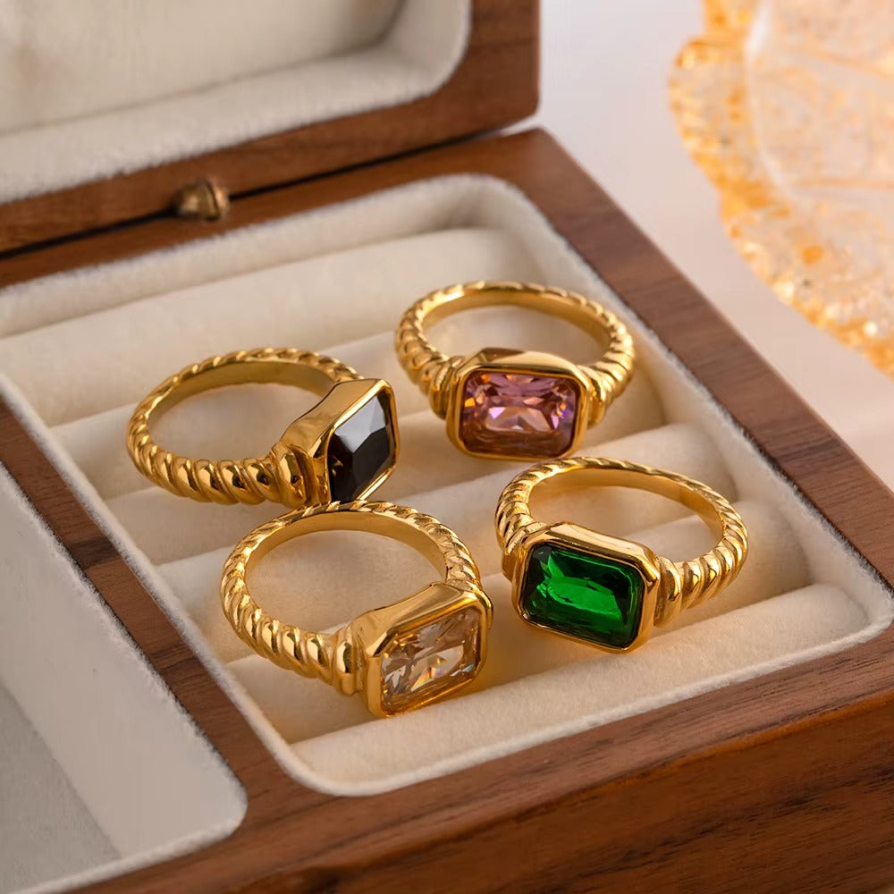 Anillo dorado con piedra zirconia cuadrada en color negro.