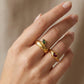 Anillo dorado con diseño de hoja color verde y corazón color rojo